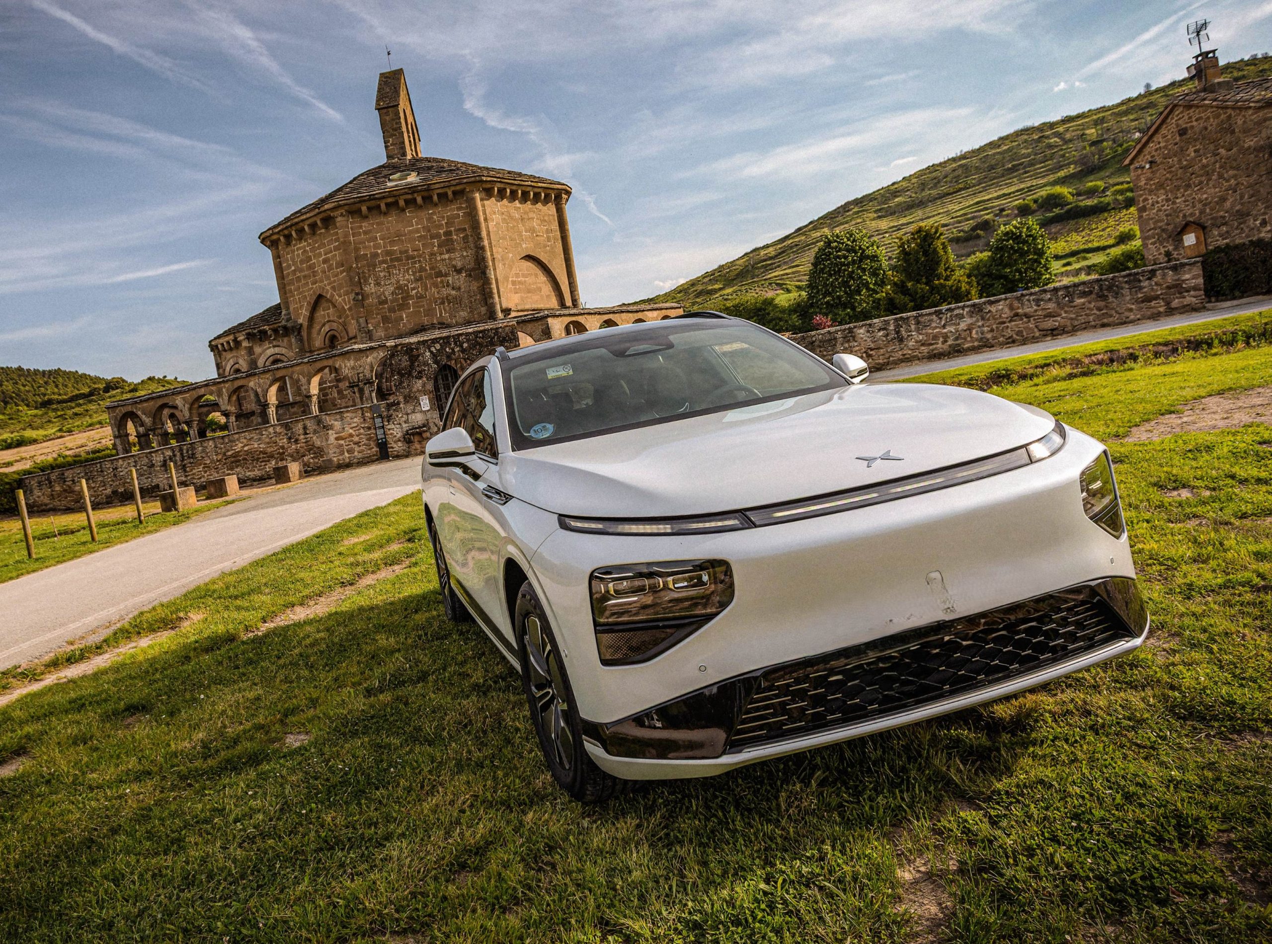 coche eléctrico sobre la hierba frente a un castillo